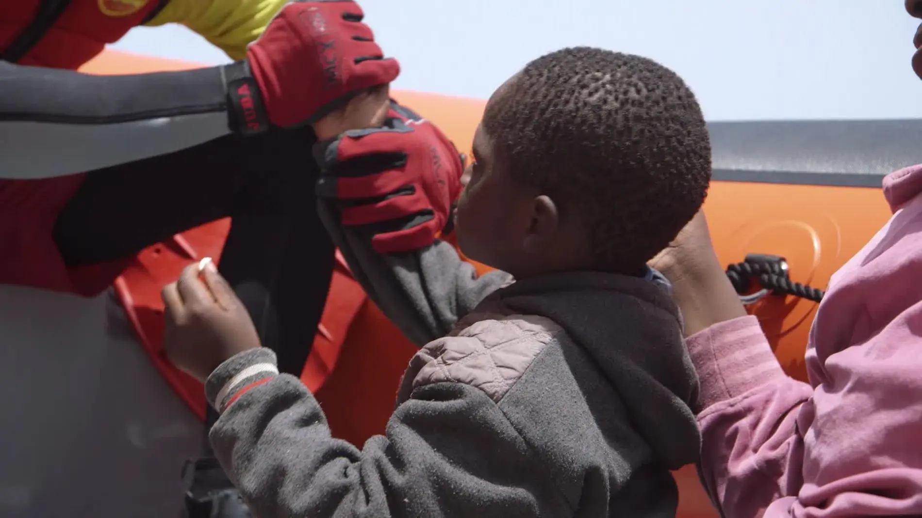 Un niño refugiado comparte un chicle con un voluntario