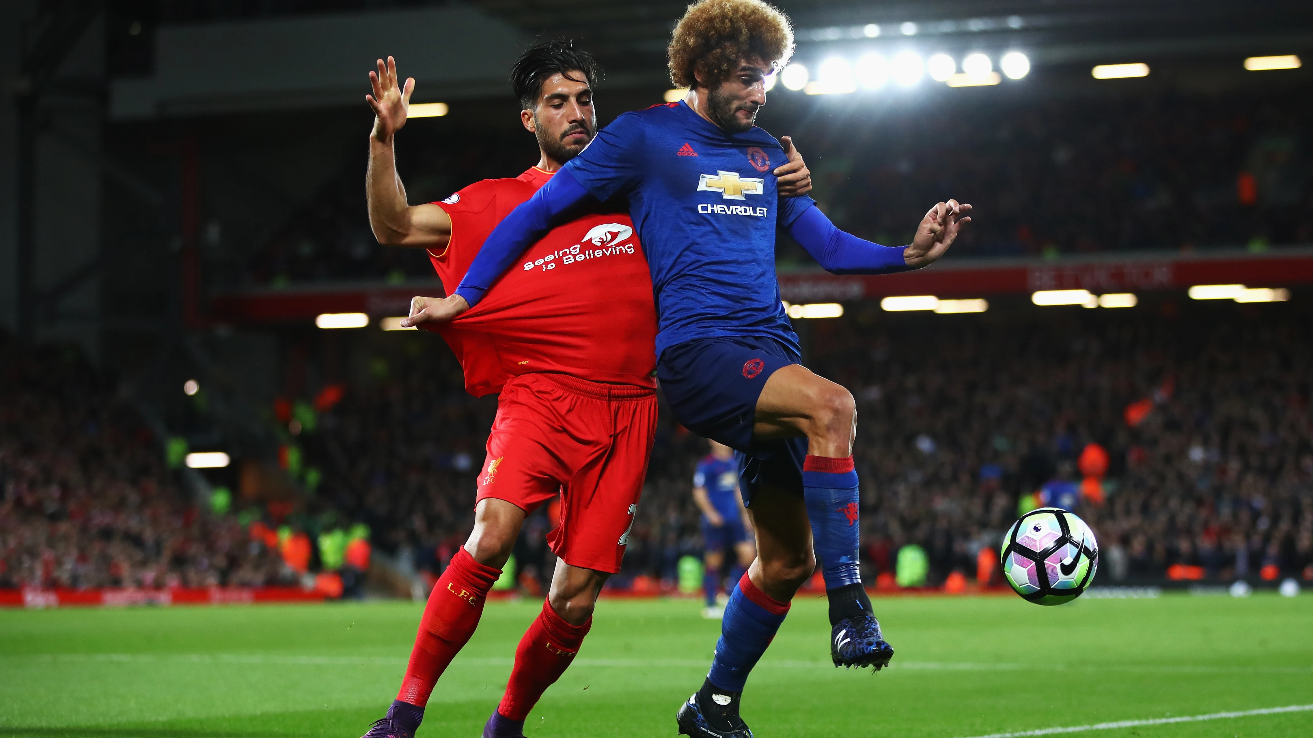 Fellaini y Emre Can disputan el balón