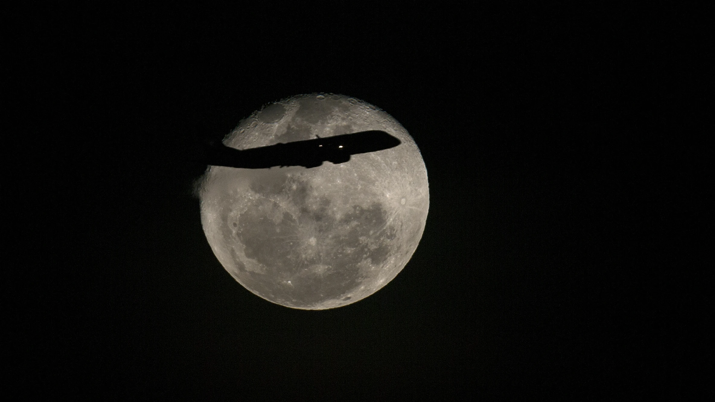 Un avión pasa frente a la luna llena en Río de Janeiro, Brasil