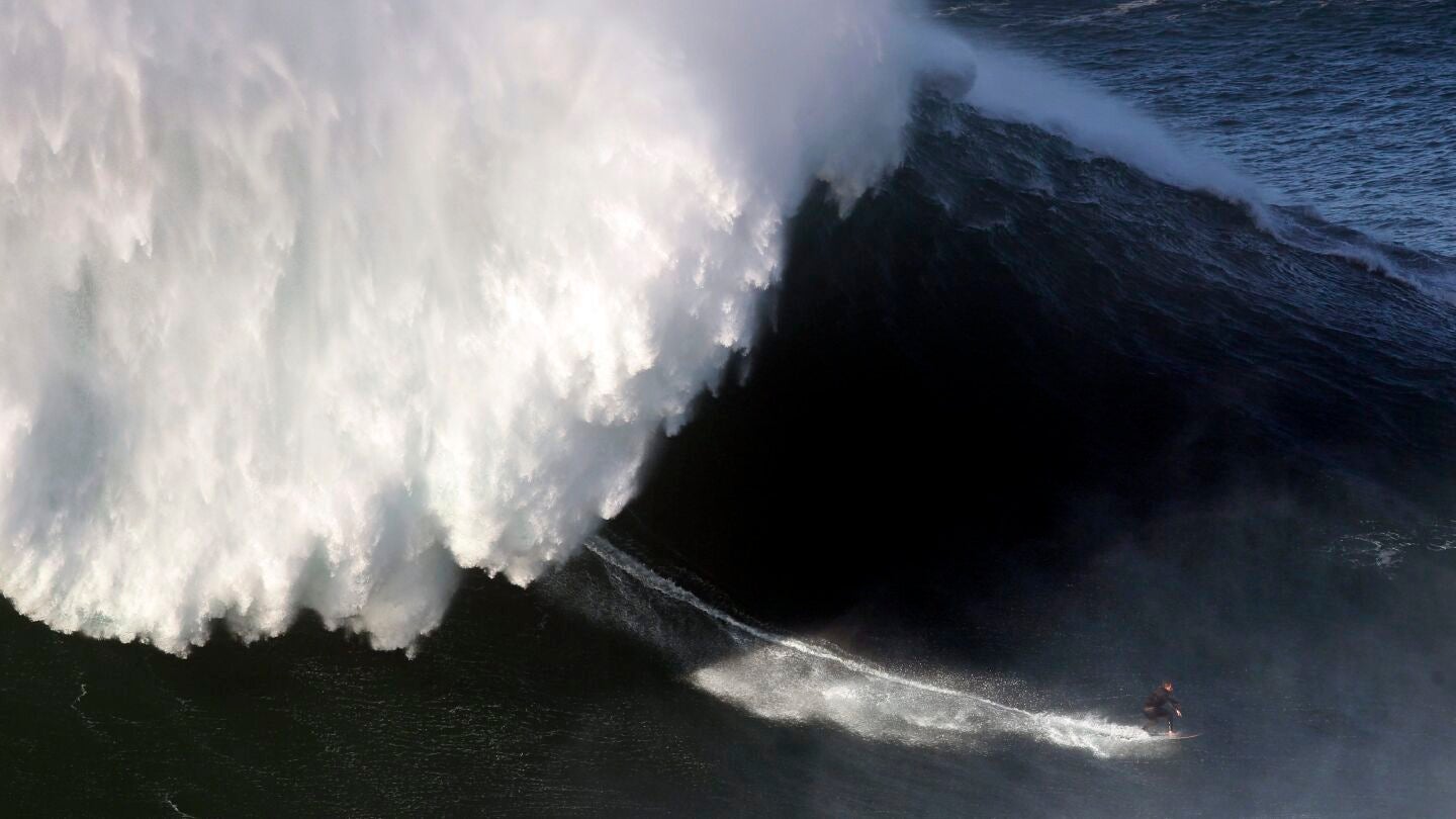 Un surfista desciende una ola en Nazar&eacute;