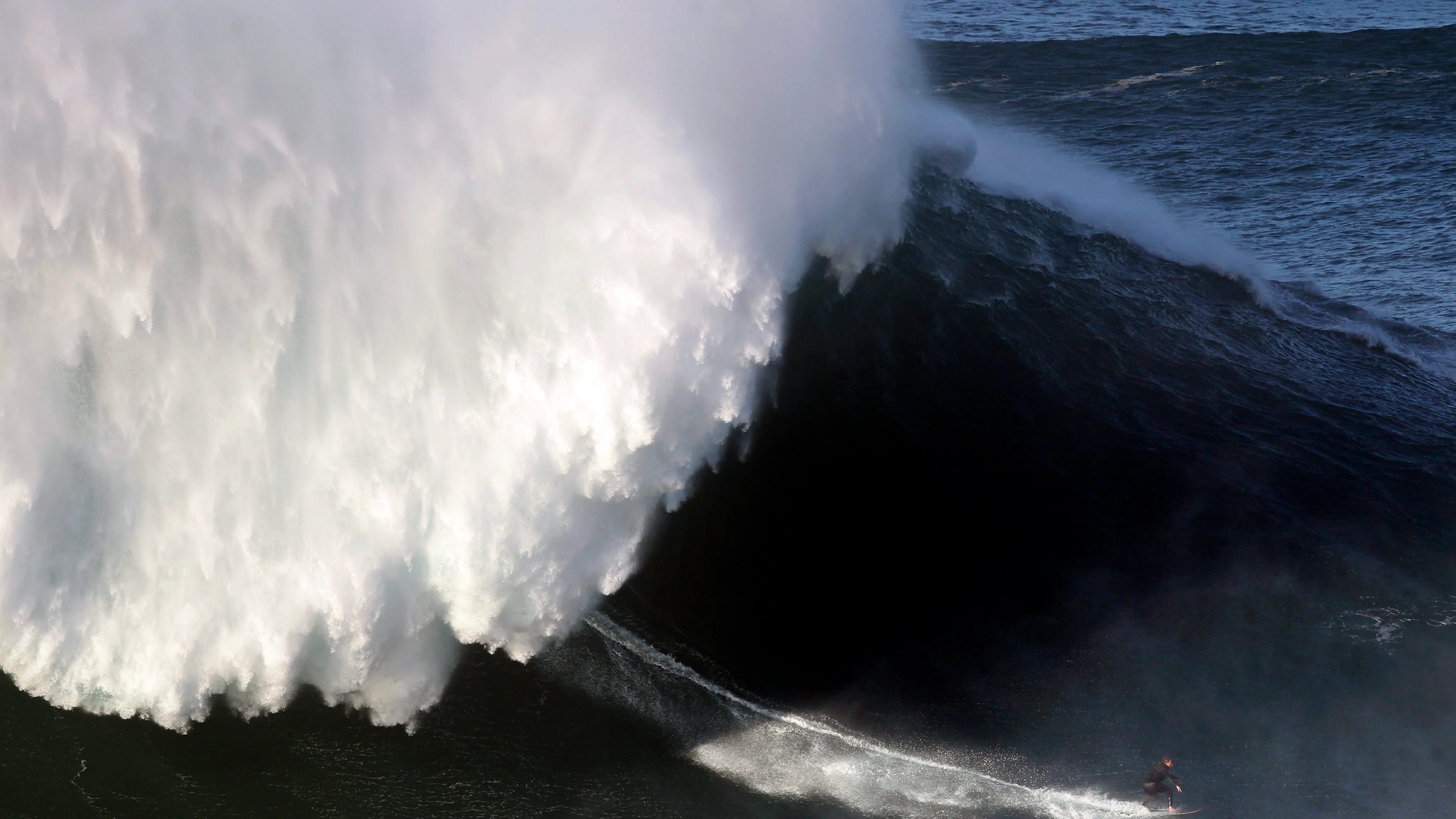 Un surfista desciende una ola en Nazaré