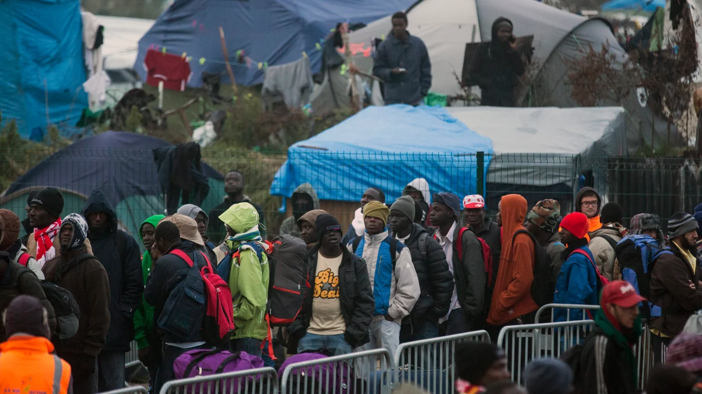 Varios migrantes esperan para su evacuación en el centro de recepción de corta estancia en el campamento conocido como "La Jungla" durante su desmantelamiento en Calais Varios migrantes esperan para su evacuación en el centro de recepción de corta estancia en el campamento conocido como "La Jungla" durante su desmantelamiento en Calais