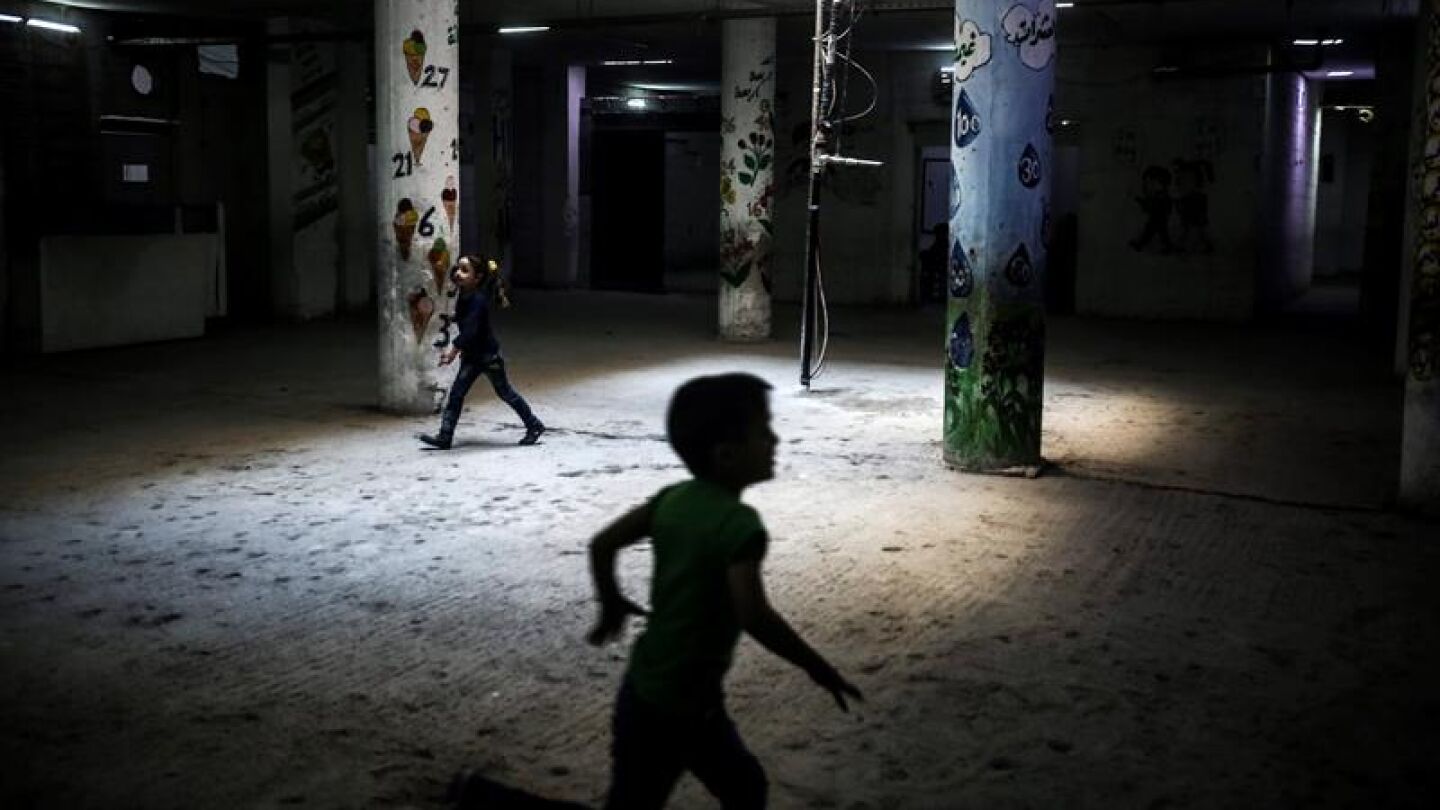 Ni&ntilde;os sirios corren por los pasillos de una escuela 