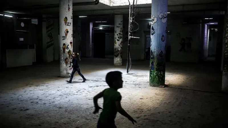 Niños sirios corren por los pasillos de una escuela 