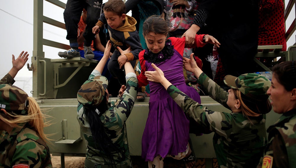 Niños bajando de un camión militar