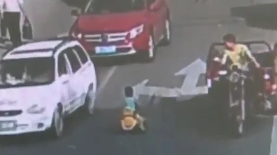 Niño conduciendo con su coche de juguete en China Niño conduciendo con su coche de juguete en China