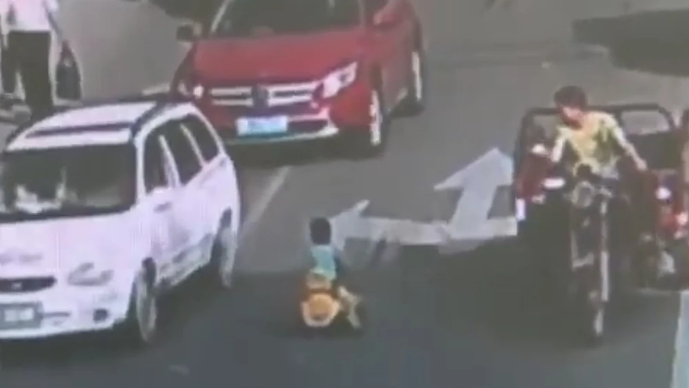 Niño conduciendo con su coche de juguete en China Niño conduciendo con su coche de juguete en China