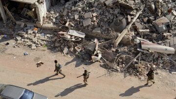 Soldados sirios caminan entre los escombros en el oeste de Alepo