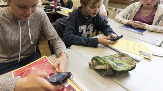 Unos alumnos utilizan el smartphone en clase Unos alumnos utilizan el smartphone en clase