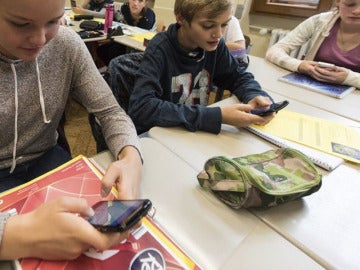 Unos alumnos utilizan el smartphone en clase Unos alumnos utilizan el smartphone en clase