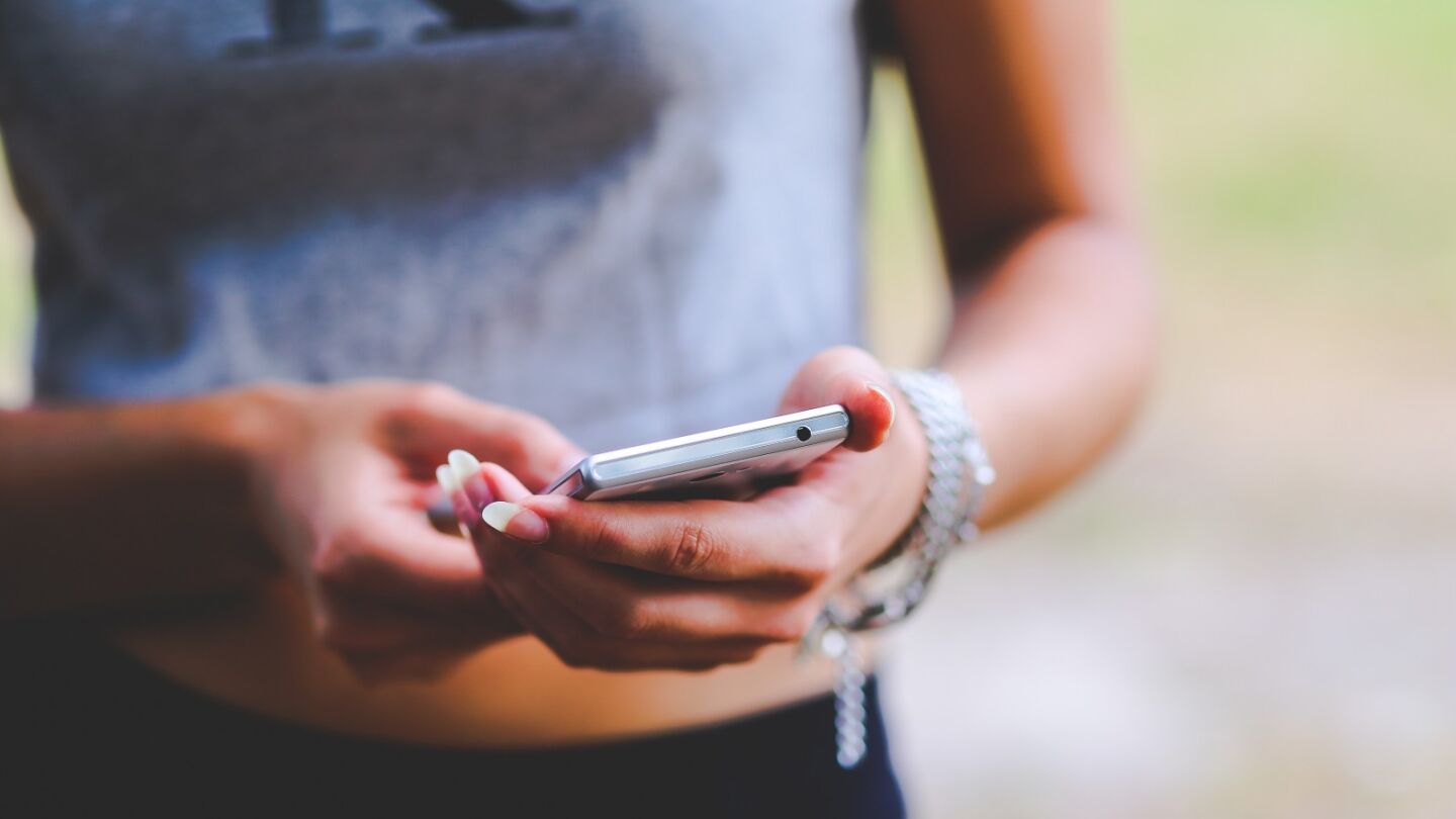 Una mujer con un tel&eacute;fono m&oacute;vil