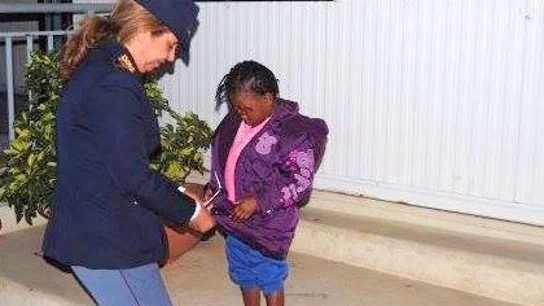 La pequeña Oumoh con una policía La pequeña Oumoh con una policía