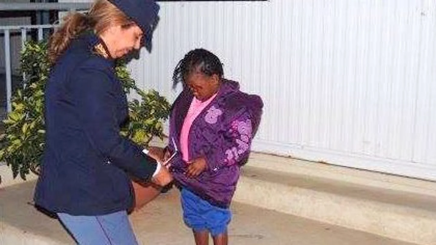 La pequeña Oumoh con una policía La pequeña Oumoh con una policía