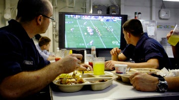 Una familia ve la televisión mientras come