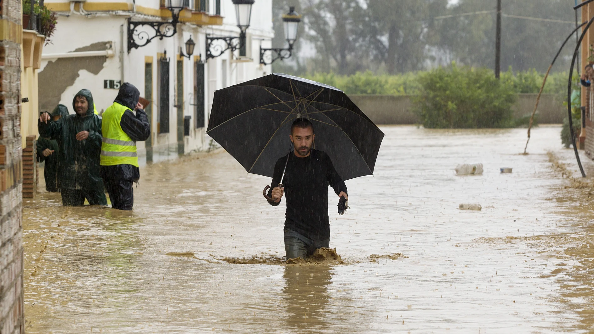 Una persona camina entre las casas inundadas en la barriada Doña Ana de la localidad malagueña de Cártama por las fuertes lluvias caídas esta noche