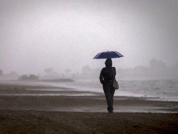 Una persona pasea por la playa de la Malvarrosa bajo la lluvia Una persona pasea por la playa de la Malvarrosa bajo la lluvia