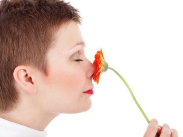 Una mujer huele una flor