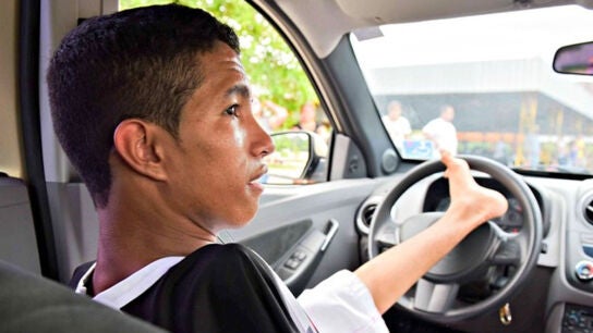 Joven conduciendo con su pie