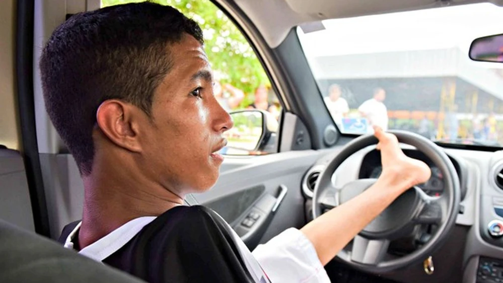 Joven conduciendo con su pie