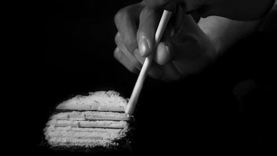 Una persona esnifando cocaína Una persona esnifando cocaína