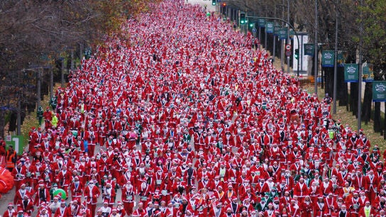 Cientos de personas vestidas de Santa Claus participan en la carrera de Pap&aacute; Noel en Madrid