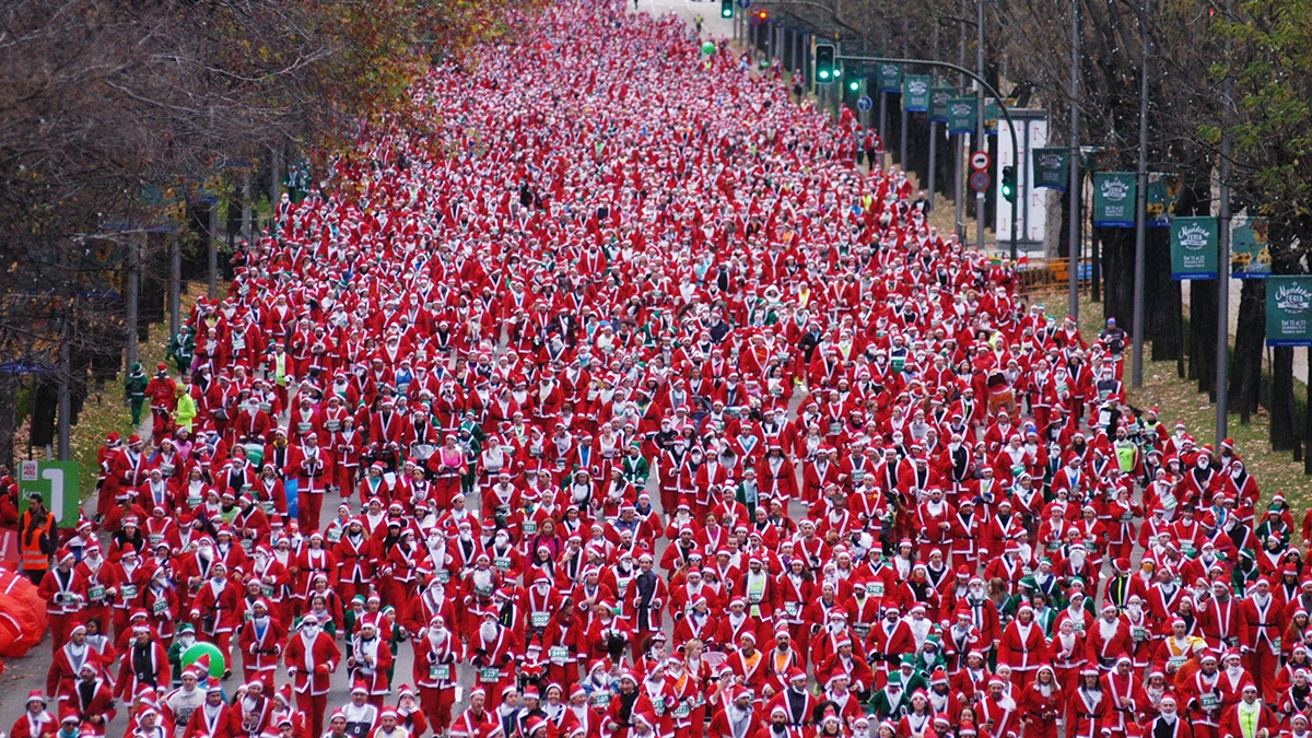 Cientos de personas vestidas de Santa Claus participan en la carrera de Papá Noel en Madrid