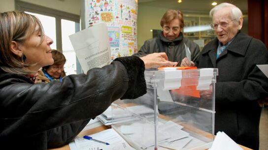 Un hombre deposita su papeleta en la urna de una de las mesas instaladas en un colegio electoral del barrio del eixample barcelon&eacute;s