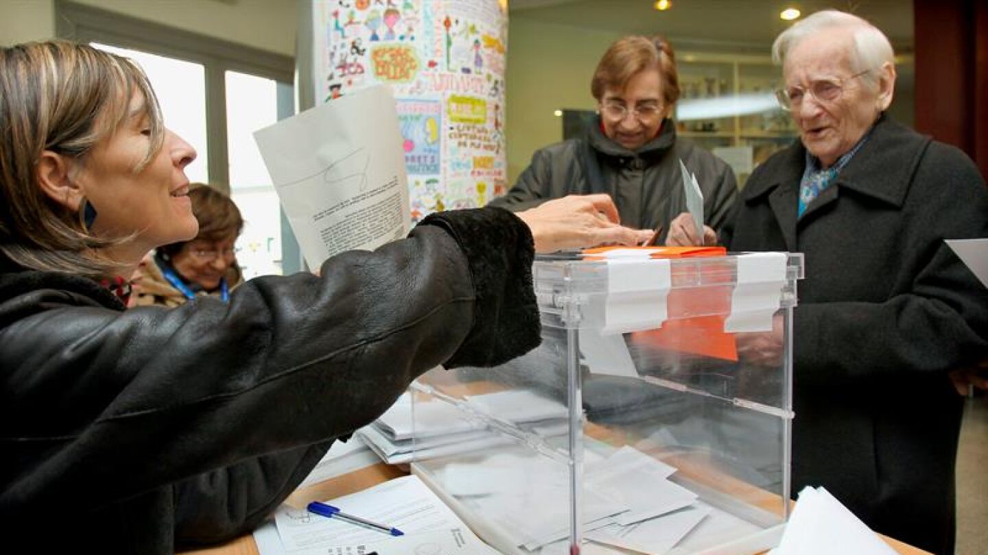 Un hombre deposita su papeleta en la urna de una de las mesas instaladas en un colegio electoral del barrio del eixample barcelon&eacute;s
