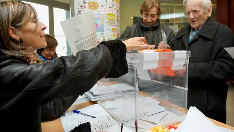 Un hombre deposita su papeleta en la urna de una de las mesas instaladas en un colegio electoral del barrio del eixample barcelonés Un hombre deposita su papeleta en la urna de una de las mesas instaladas en un colegio electoral del barrio del eixample barcelonés