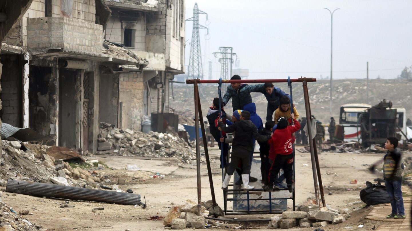 Ni&ntilde;os sirios juegan entre las ruinas de una ciudad arrasada por la guerra