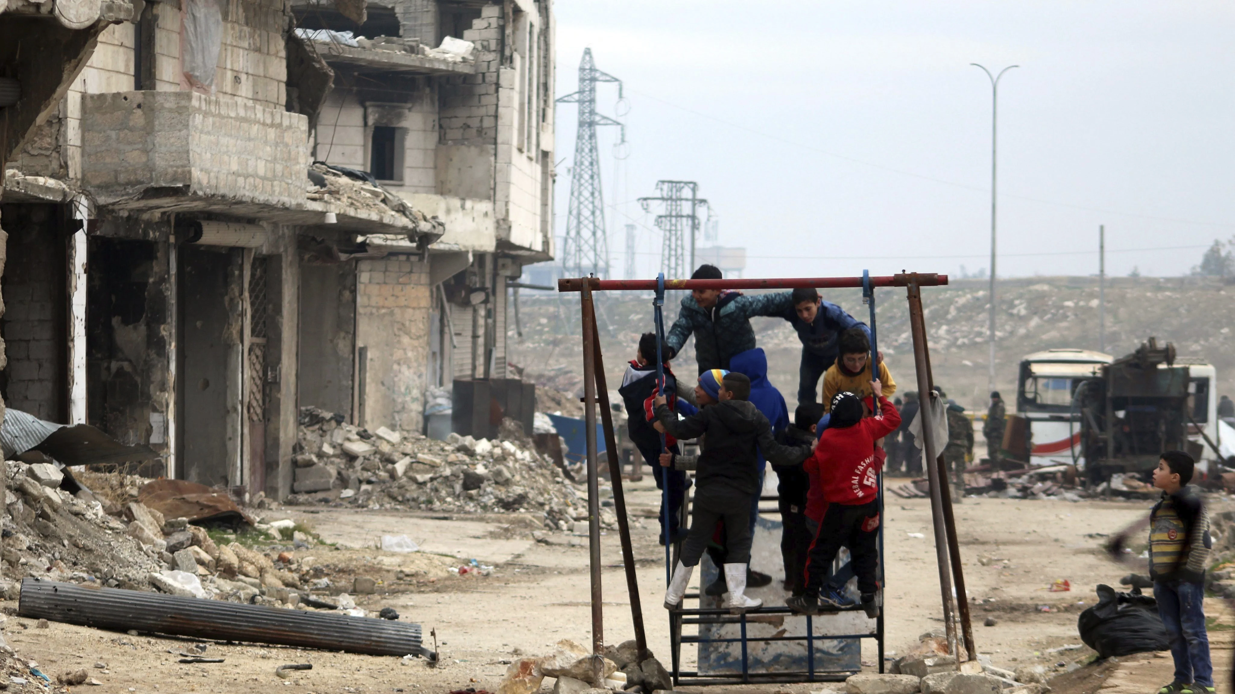 Niños sirios juegan entre las ruinas de una ciudad arrasada por la guerra