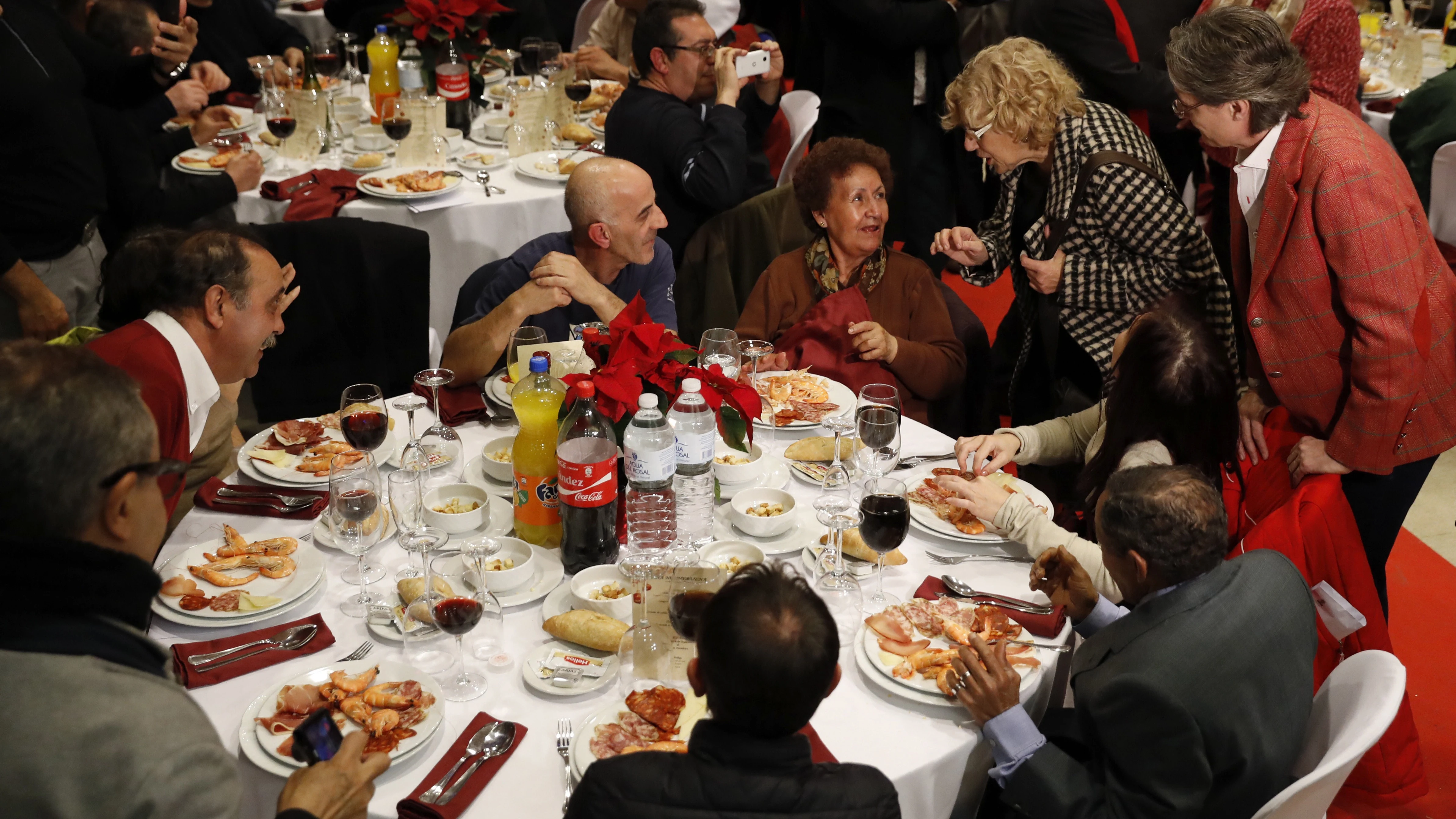 La alcaldesa de Madrid, Manuela Carmena (2ªd), y la vicealcaldesa Marta Higueras (d), felicitan la Navidad a las casi 200 personas sin hogar que acuden a la cena de Nochebuena organizada por Mensajeros de la Paz