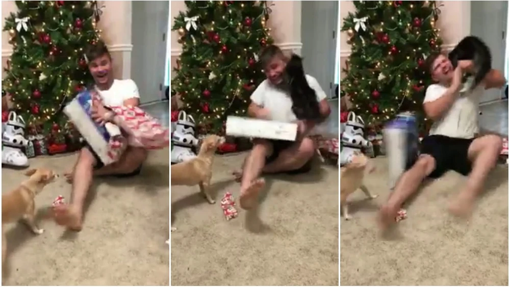 Un gato ataca a su amo mientras abre los regalos de Navidad Un gato ataca a su amo mientras abre los regalos de Navidad