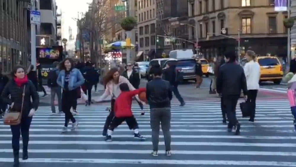 Un niño dribla a una mujer en medio de la calle