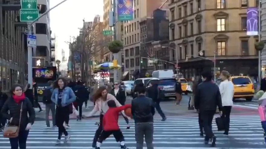 Un niño dribla a una mujer en medio de la calle Un niño dribla a una mujer en medio de la calle