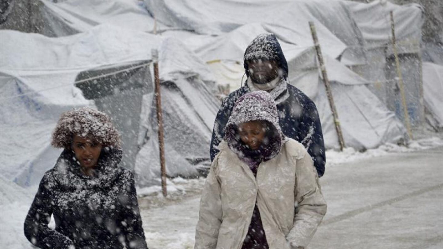 Varios refugiados caminan bajo la nieve en el campamento de refugiados de Moria