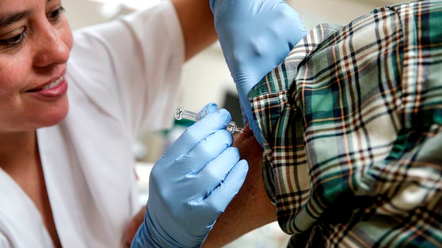 Enfermera administrando la vacuna de la Gripe