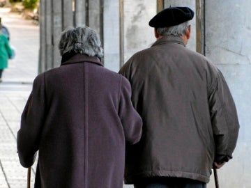Una pareja de ancianos pasea por la calle Una pareja de ancianos pasea por la calle
