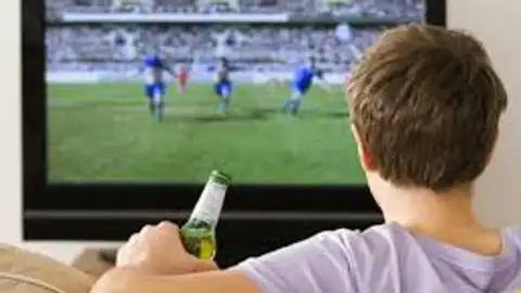 Hombre viendo un partido de fútbol por televisión Hombre viendo un partido de fútbol por televisión
