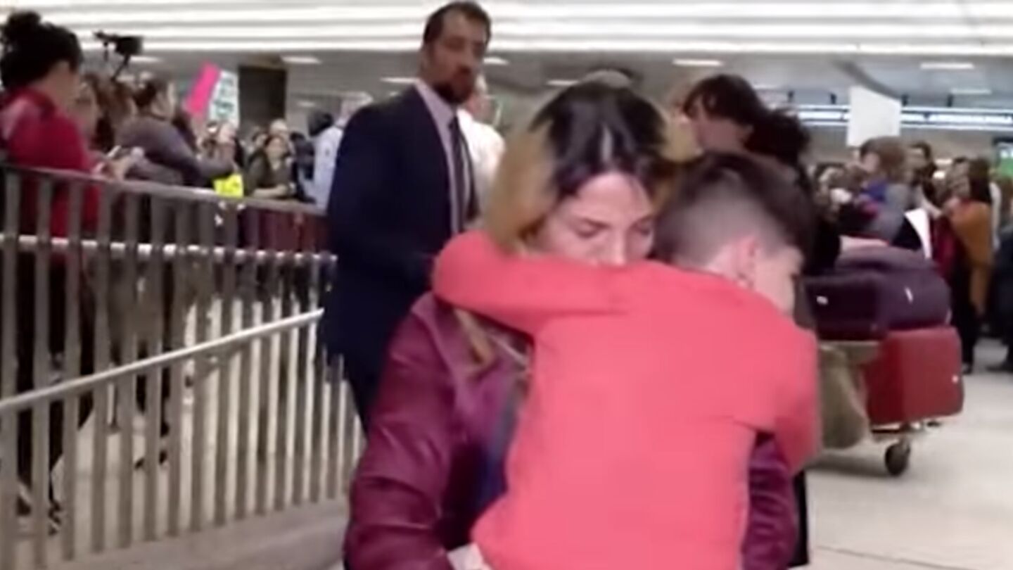 Un ni&ntilde;o y su madre iran&iacute; se abrazan tras sufrir el veto de Trump