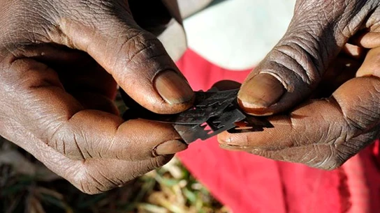 Una mujer africana sostiene varias cuchillas Una mujer africana sostiene varias cuchillas