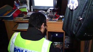 Un Mosso d'Escuadra realiza un registro dentro de la operación contra la distribución de pornografía infantil a través de Internet