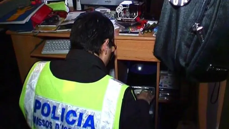 Un Mosso d'Escuadra realiza un registro dentro de la operación contra la distribución de pornografía infantil a través de Internet