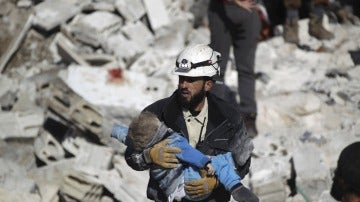 Un casco blanco sirio rescatando a un menor sepultado bajo los escombros