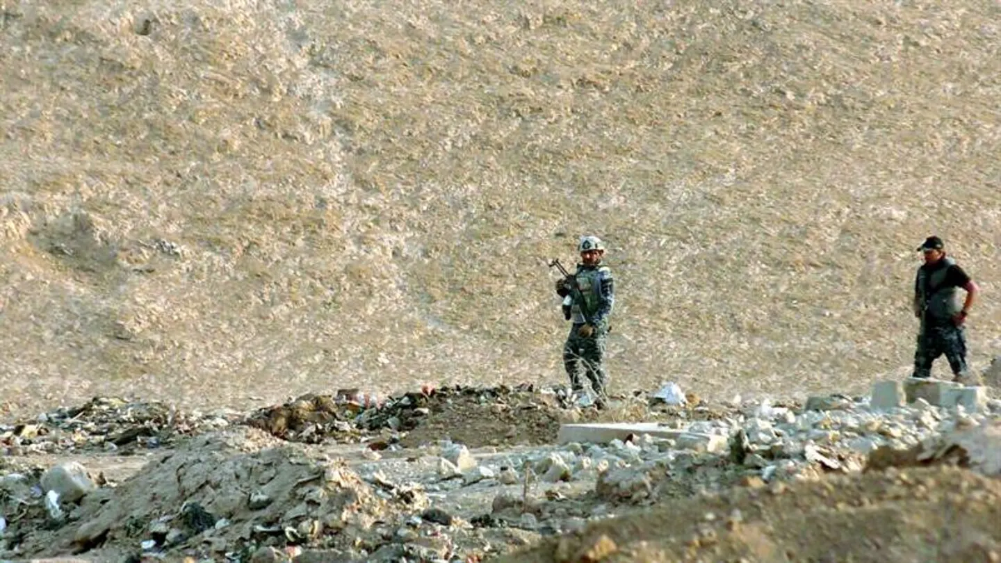Oficiales iraquíes inspeccionan una zona en la que fue descubierta una fosa común, al sur de Mosul Oficiales iraquíes inspeccionan una zona en la que fue descubierta una fosa común, al sur de Mosul