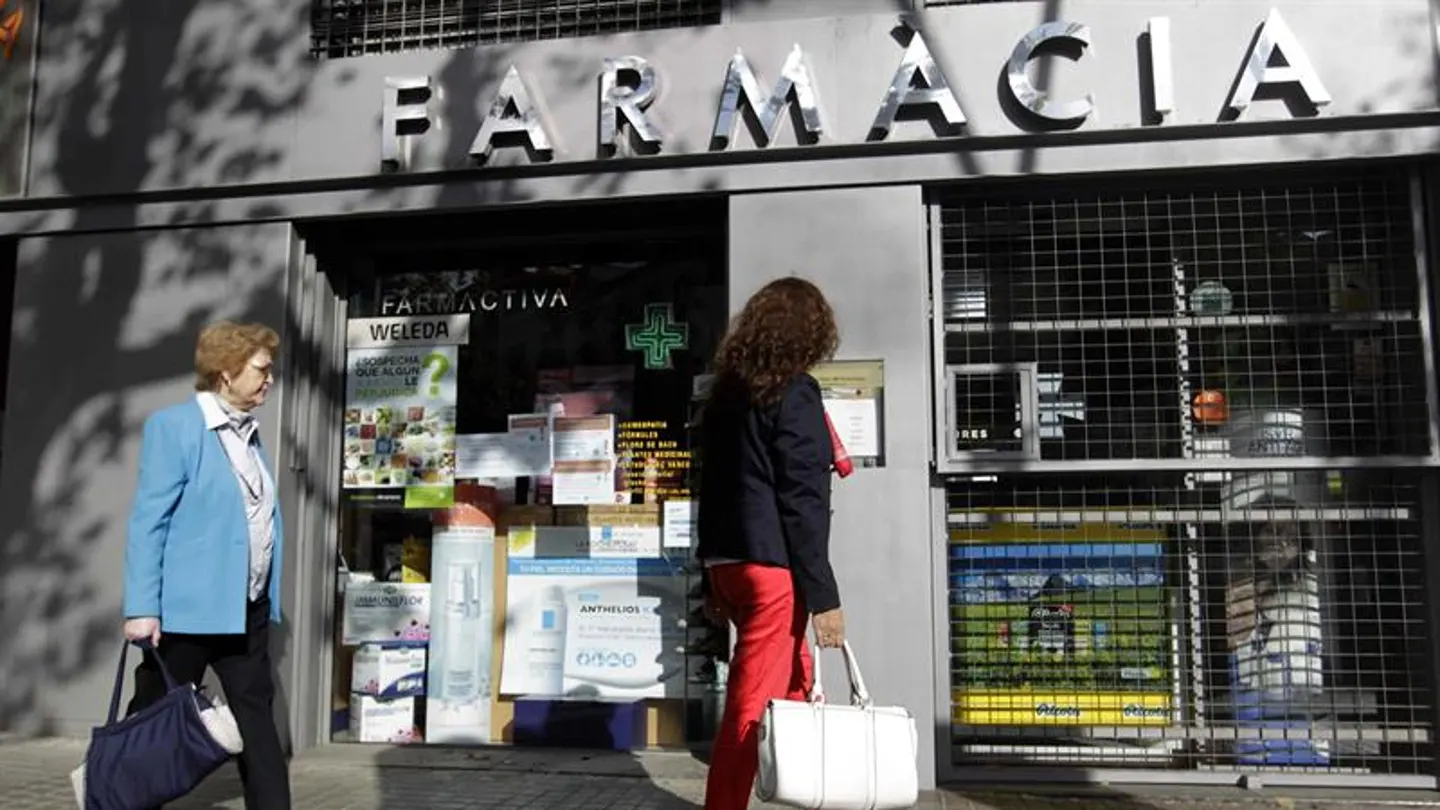 Una mujer pasa por una farmacia en el centro de Barcelona Una mujer pasa por una farmacia en el centro de Barcelona