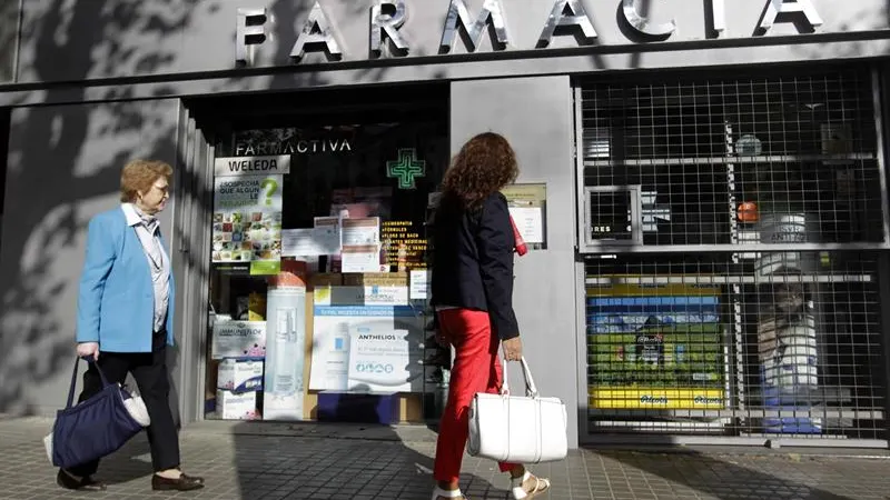 Una mujer pasa por una farmacia en el centro de Barcelona