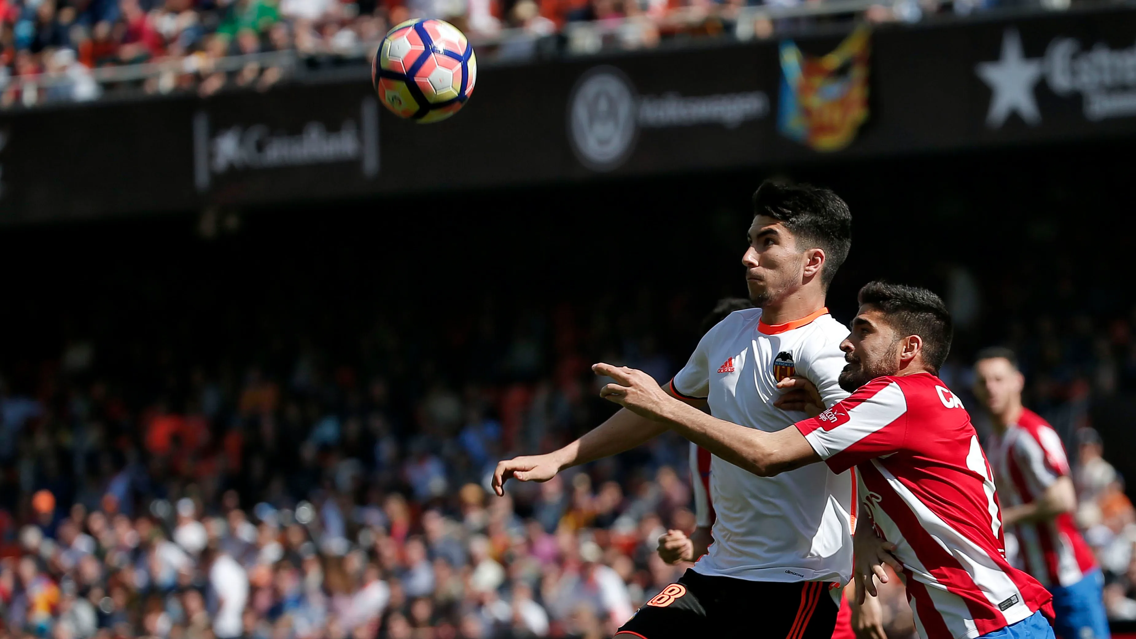 Soler y Carmona luchan por alto la posesión del esférico durante el Valencia - Sporting