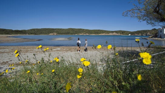 Dos personas caminan por la playa del Parque Natural de Es Grau