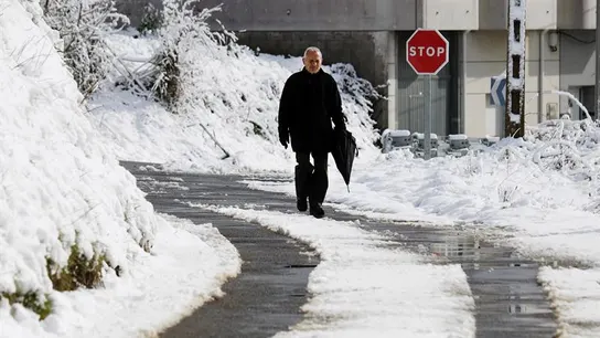 Un hombre caminando por la nieve Un hombre caminando por la nieve